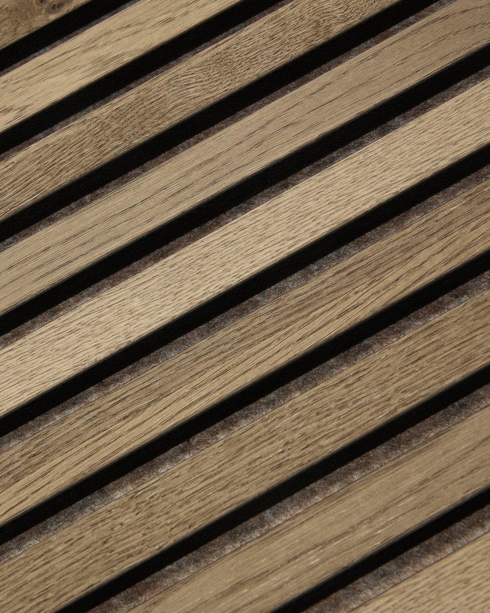 Primer plano de WoodUpp Tonal Akupanel Panel acústico en Grey Oak (240x60 cm), que muestra lamas diagonales espaciadas de forma uniforme con veta de natural oak y diseño nórdico.